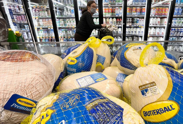 A shopper walks past turkeys for sale in a Los Angeles grocery store ahead of the Thanksgiving holiday